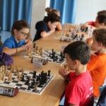 Jeunes joueurs concentrés sur leurs échiquiers lors de la compétition interdépartementale Loiret-Essonne.