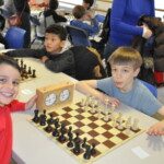 Deux jeunes joueurs souriants devant leur échiquier au Grand Prix Jeunes de l'Essonne à Gif.