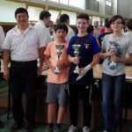 Trois jeunes joueurs récompensés posent avec leurs coupes à la finale du Grand Prix des jeunes de l'Essonne.