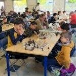 Joueurs de tous âges attablés côte à côte devant leurs échiquiers dans la salle du 22e Open de Gif.