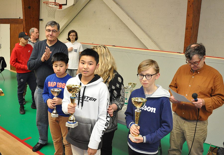 Trois jeunes joueurs reçoivent leurs coupes lors de la remise des prix de l'étape de Nozay.