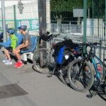 Deux cyclistes en pause sur un banc à côté de leurs vélos chargés, sur la route de l'Open de Dieppe.