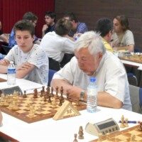 Deux joueurs du club, un jeune et un vétéran, côte à côte devant leurs échiquiers au tournoi d'Avoine.