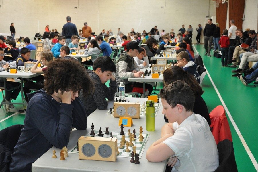 Nombreux jeunes joueurs attablés dans le gymnase lors de l'étape de Nozay du Grand Prix de l'Essonne.