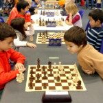 Jeunes joueurs regroupés autour d'un échiquier lors des championnats jeunes de l'Essonne.