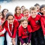 Groupe de jeunes joueurs en maillot rouge du club, tout sourire, au Championnat de France 2014 à Montbéliard.