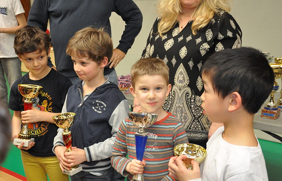 Jeunes enfants tenant fièrement leurs coupes à l'étape de Nozay du Grand Prix de l'Essonne.