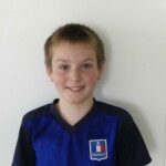 Adrien Portrait souriant d'un jeune joueur du club en maillot bleu lors du goûter de fin de saison.