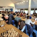 Salle comble du 22e Open de Gif, joueurs de tous âges alignés de part et d'autre des longues tables.